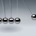 Dynamic illustration of Newton's Cradle showing motion and reflection concepts in physics.