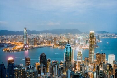 Explore the breathtaking skyline of Hong Kong at dusk, highlighting vibrant lights and Victoria Harbor.