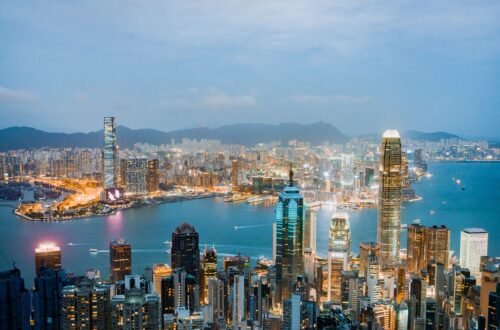 Explore the breathtaking skyline of Hong Kong at dusk, highlighting vibrant lights and Victoria Harbor.